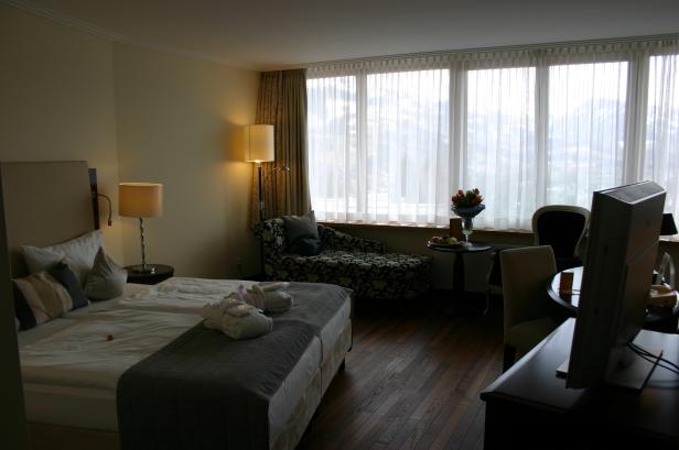 Ein Hotelzimmer mit Doppelbett, Sitzecke und Blick auf die Berge.