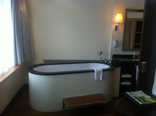 Ein Badezimmer mit einer freistehenden Badewanne und einem kleinen Hocker.