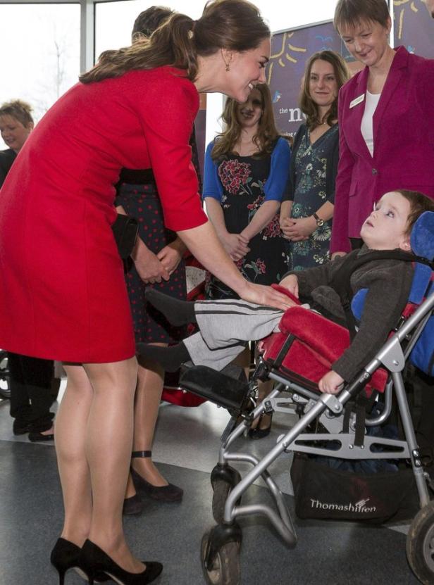 Catherine, Princess of Wales, interagiert mit einem Kind im Rollstuhl.