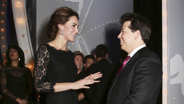 Kate Middleton unterhält sich lächelnd mit einem Mann im Anzug.