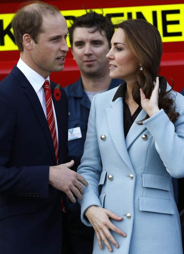 Prinz William und Prinzessin Kate in einem Gespräch vor einem roten Hintergrund.