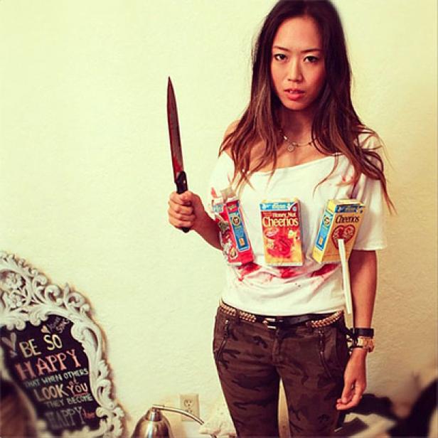 Eine Frau in einem „Cereal Killer“-Kostüm mit einem blutigen Messer in der Hand.