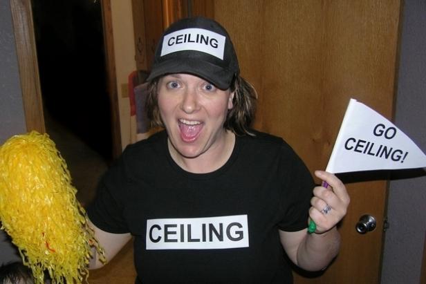 Eine Frau mit einem „Ceiling“-T-Shirt und einer Fahne feuert die Decke an.