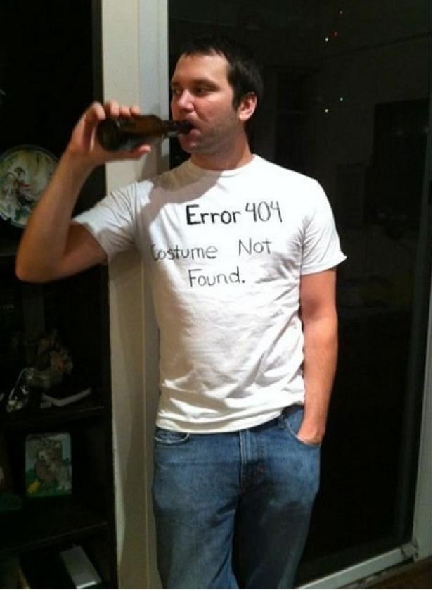 Ein Mann mit einem T-Shirt mit der Aufschrift „Error 404 Costume Not Found“ trinkt ein Bier.