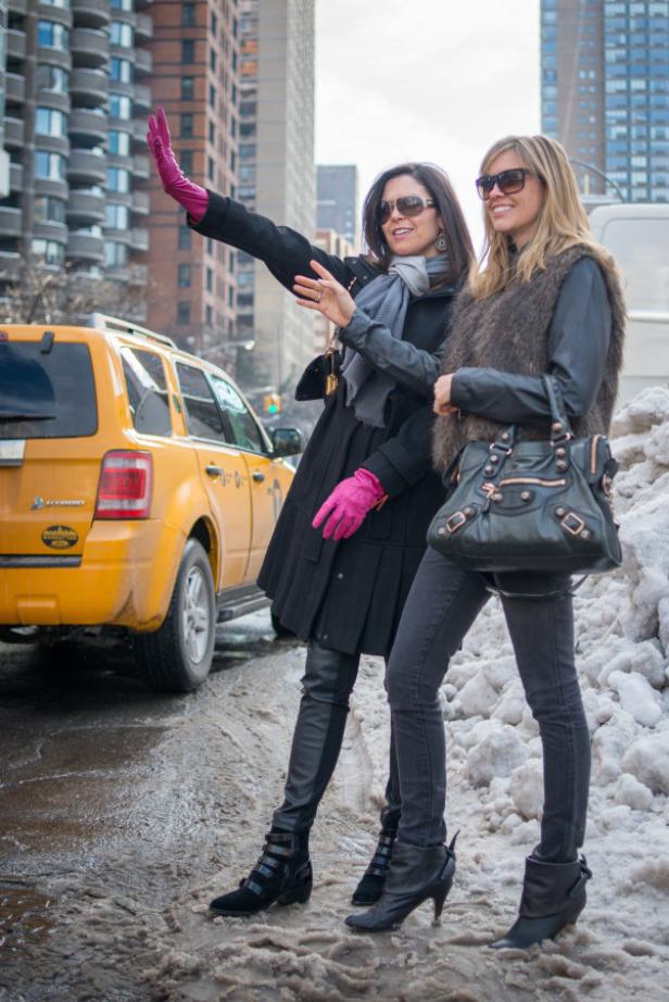 Zwei Frauen winken in New York ein Taxi heran.