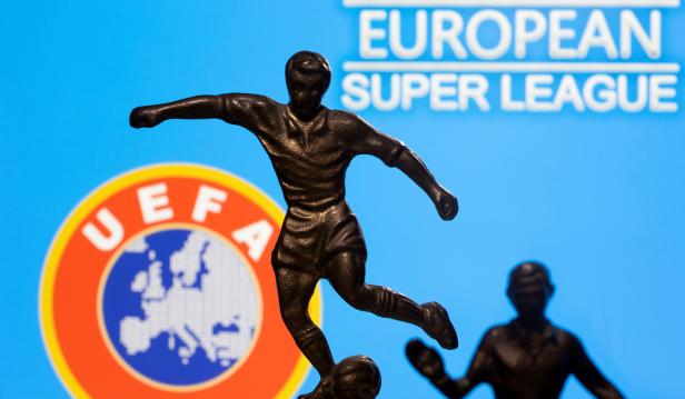 FILE PHOTO: Metal figures of football players are seen in front of the words "European Super League" and the UEFA logo in this illustration