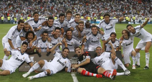 Die Fußballmannschaft von Real Madrid feiert einen Sieg mit einem Pokal.