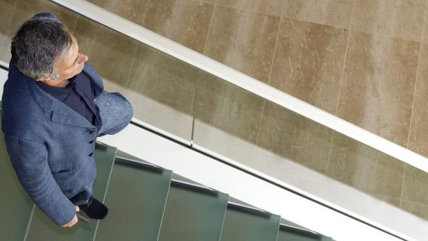 Ein Mann in einem blauen Sakko geht eine Treppe hinunter.