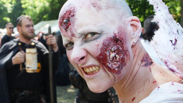 Eine Frau mit blutigem Zombie-Make-up blickt grimmig in die Kamera.