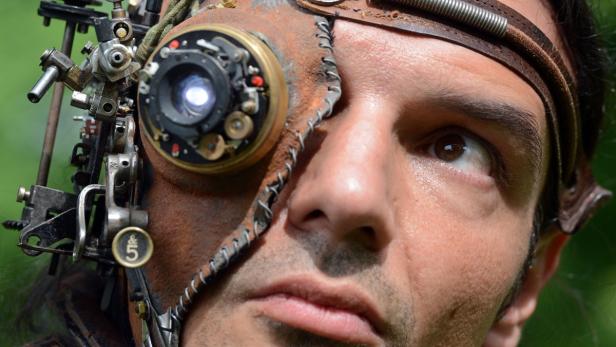 Ein Mann mit einer Steampunk-Augenprothese, bestehend aus Zahnrädern und Leder.