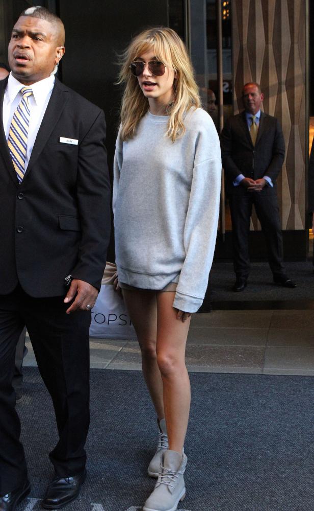Hailey Bieber verlässt ein Gebäude mit einem Bodyguard.