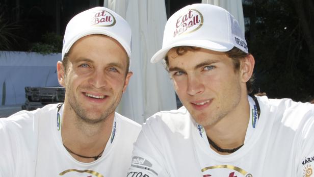 Zwei Männer mit Kappen mit der Aufschrift „Eat the Ball“ lächeln in die Kamera.