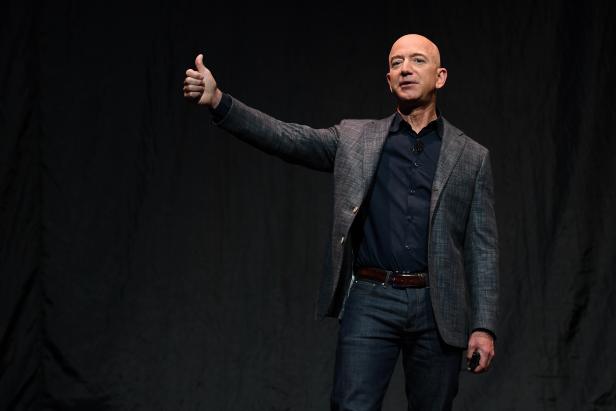 FILE PHOTO: Founder, Chairman, CEO and President of Amazon Jeff Bezos gives a thumbs up as he speaks during an event about Blue Origin's space exploration plans in Washington