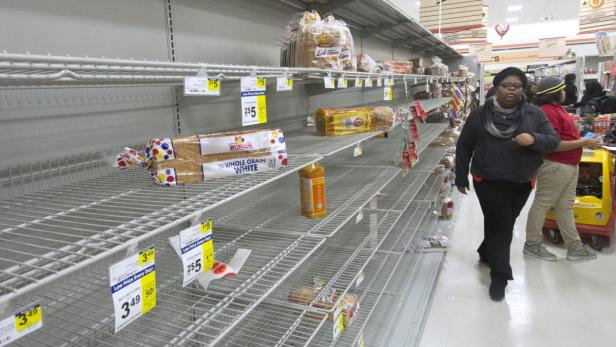 Regale mit wenigen Brotlaiben in einem Supermarkt.