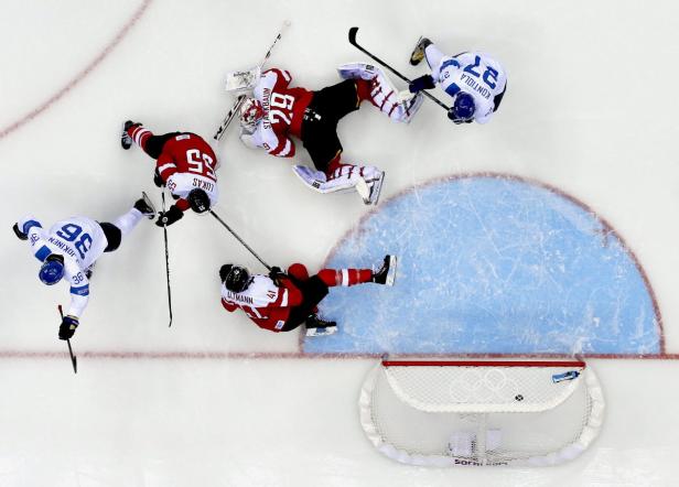 Draufsicht auf ein Eishockeyspiel zwischen Österreich und Finnland vor dem Tor.