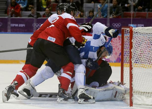 Eishockeyspieler kämpfen vor dem Tor um den Puck.