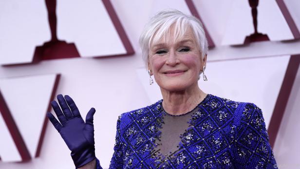 Glenn Close auf dem roten Teppich in einem blau-schwarzen Kleid und Handschuhen.