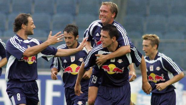 Mehrere Fußballspieler von Red Bull Salzburg feiern gemeinsam auf dem Spielfeld.