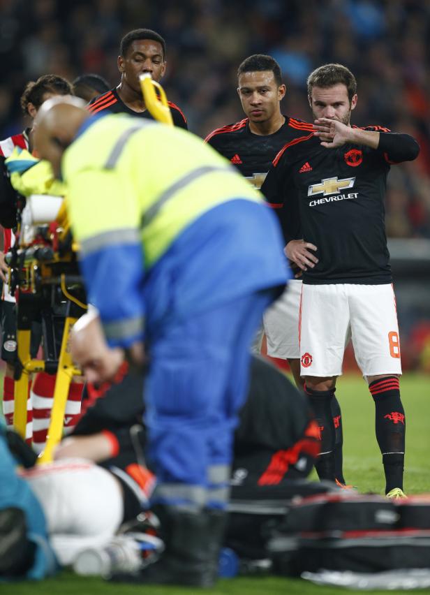 Sanitäter kümmern sich um einen verletzten Fußballspieler, während andere Spieler zusehen.