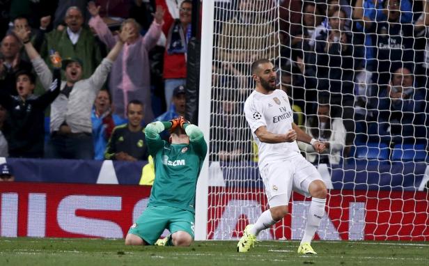 Karim Benzema jubelt, während der gegnerische Torwart enttäuscht am Boden kniet.