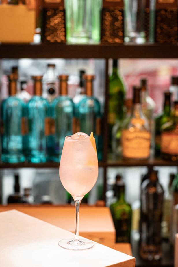 Ein „Rubin Spritz“ Cocktail steht auf einer Bar.