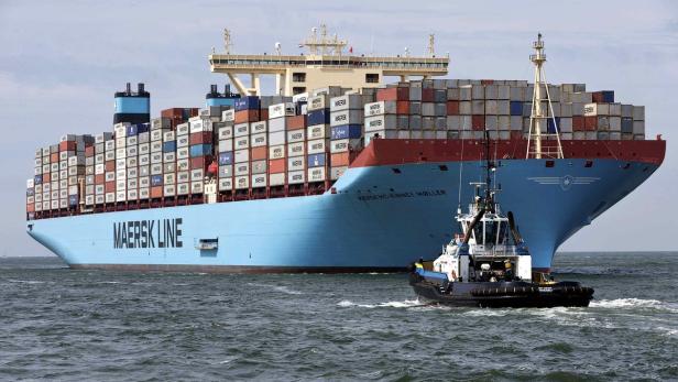 Ein Containerschiff der Maersk Line wird von einem Schlepper begleitet.