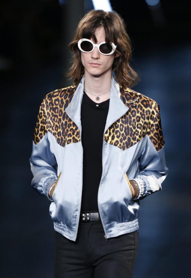 Ein Mann mit Sonnenbrille trägt eine hellblaue Jacke mit Leopardenmuster.