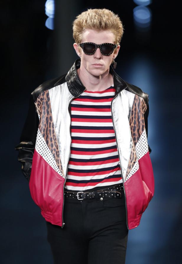 Ein Mann mit Sonnenbrille und einer Jacke mit Leopardenmuster und Nieten.