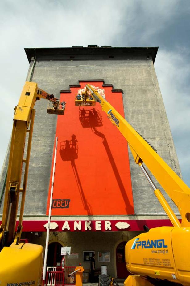Zwei gelbe Kräne arbeiten an der Fassade des Anker-Gebäudes.