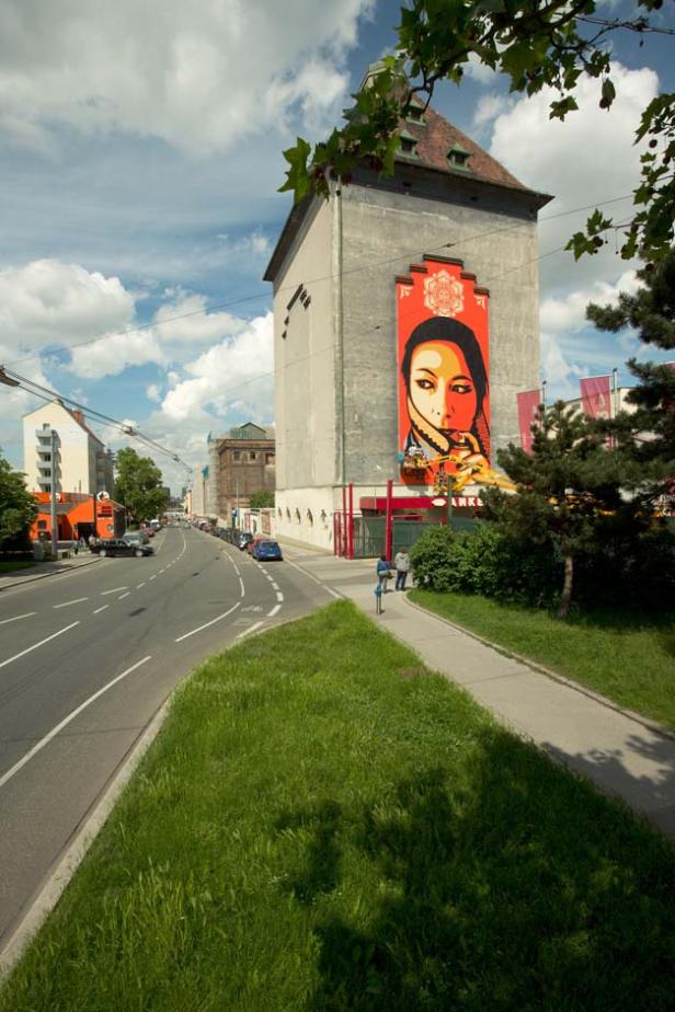 Ein Gebäude in Wien mit einem großen Porträtgemälde an der Fassade.