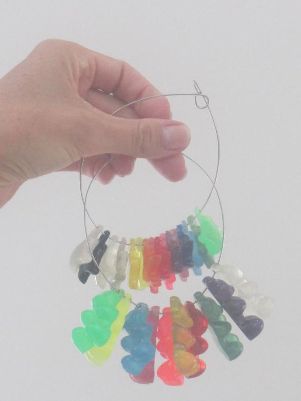 Eine Hand hält einen Reifen mit bunten Gummibärchen-Anhängern.