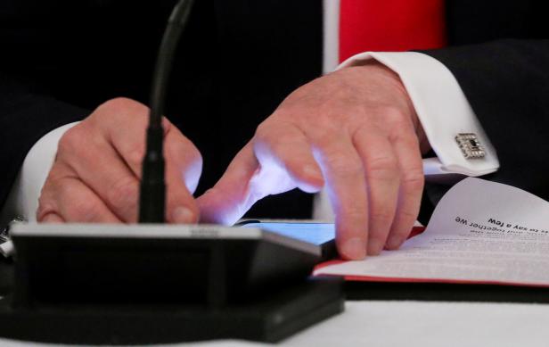 FILE PHOTO: FILE PHOTO: U.S. President Trump uses phone during roundtable discussion on the reopening of U.S. economy at the White House in Washington