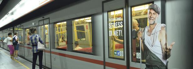 Eine U-Bahn steht an einer Haltestelle, Fahrgäste warten auf den Einstieg.