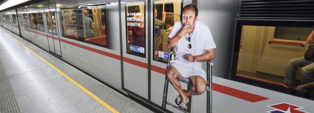 Ein Mann in Shorts sitzt auf einer Leiter vor einer U-Bahn-Tür.