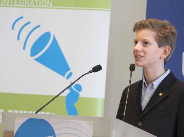 Ein junger Mann hält eine Rede vor einem Publikum.