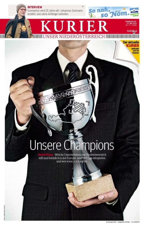 KURIER launcht Wirtschaftsmagazin "Unser Niederöst Ein Mann im Anzug hält einen silbernen Pokal mit einer Weltkarte in den Händen.