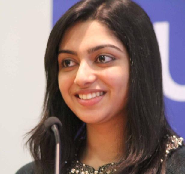 Eine junge Frau lächelt vor einem Mikrofon.