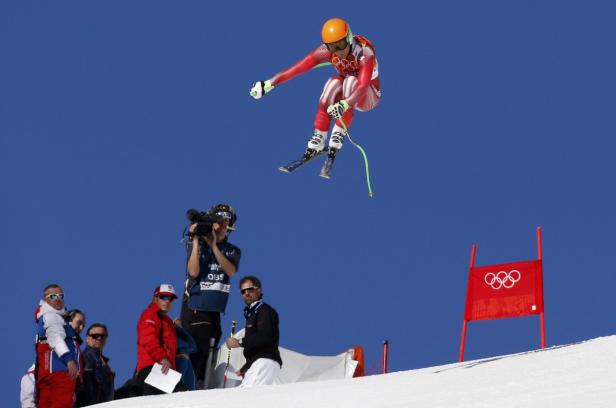 Ein Skifahrer springt vor dem Hintergrund eines blauen Himmels.