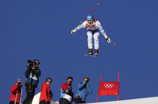 Ein Skifahrer springt vor dem Hintergrund eines strahlend blauen Himmels.