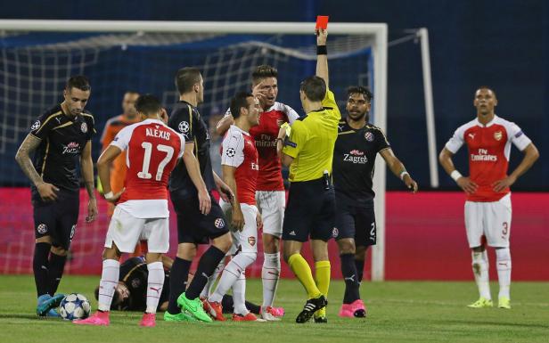 Ein Schiedsrichter zeigt einem Fußballspieler die Rote Karte.