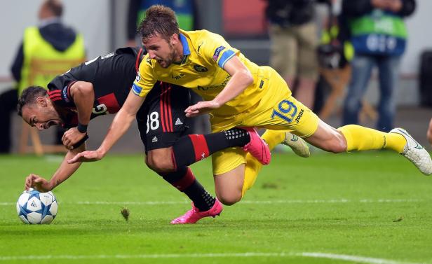 Zwei Fußballspieler kämpfen um den Ball auf dem Spielfeld.