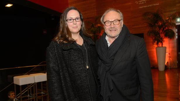 Eine Frau mit Brille und ein Mann mit Schal posieren für ein Foto.