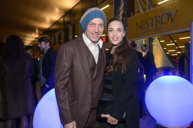 Ein Mann mit Mütze und eine Frau posieren vor dem Nestroy-Theater.