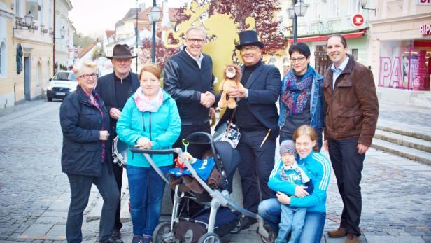 Eine Gruppe von Menschen posiert auf einer Straße für ein Foto.