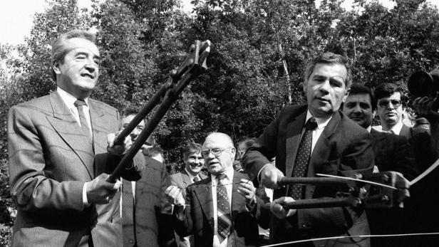 Lech Walesa durchtrennt mit einer großen Zange Stacheldraht.