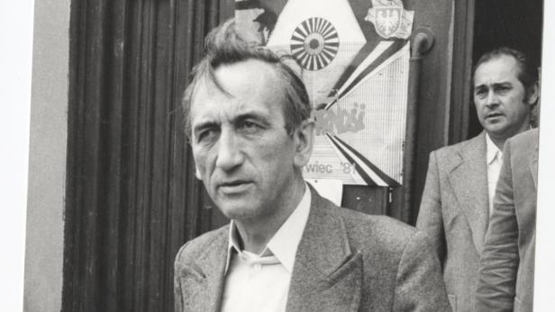 Ein Porträt von Lech Wałęsa vor einem Plakat der Solidarność-Bewegung.