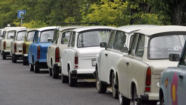 Eine Reihe von Trabant-Autos parkt am Straßenrand.
