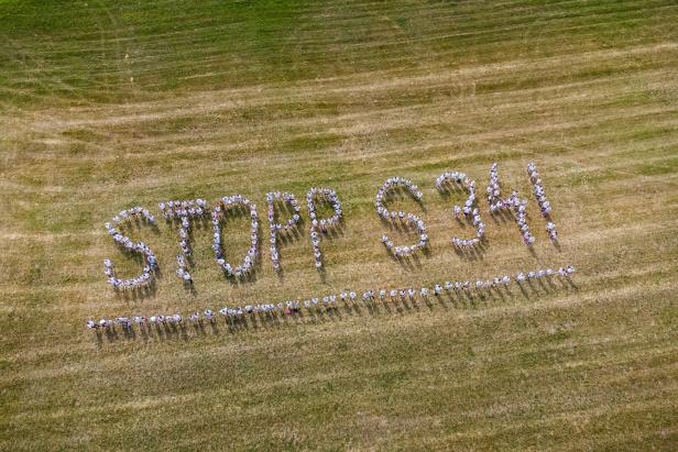 Menschenkette mit dem Schriftzug Stopp S34