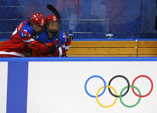 Zwei russische Eishockeyspieler umarmen sich auf der Bank während eines Spiels bei den Olympischen Spielen.