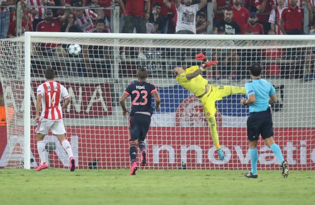 Ein Torwart in gelber Sportkleidung wehrt einen Ball ab.